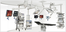 An OR suite with multiple ceiling-mounted monitors displaying medical images